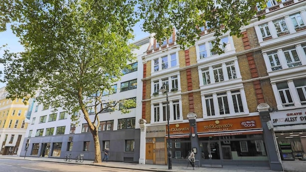 A street view with a row of buildings, including a bar named 'Souvlaki Bar' and a restaurant named 'Grays Inn Road'. - Luxurious Two Bedroom Penthouse (London)
