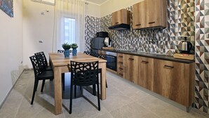 Een moderne keuken met houten kastjes, een eettafel met stoelen en een backsplash met een geometrisch patroon.