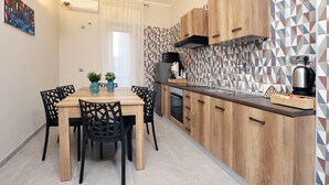 Een moderne keuken met houten kastjes, een eettafel met stoelen en een decoratieve spatwand.