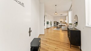 Ein modernes Interieur mit Holzboden, einer schwarzen Bank, einer schwarzen Konsole und einer weißen Wand mit dem Schriftzug "Castillo".