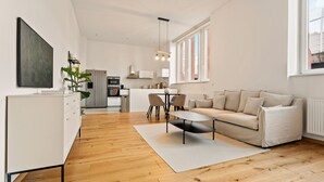 Ein modernes Wohnzimmer mit Sofa, Couchtisch und Essbereich.