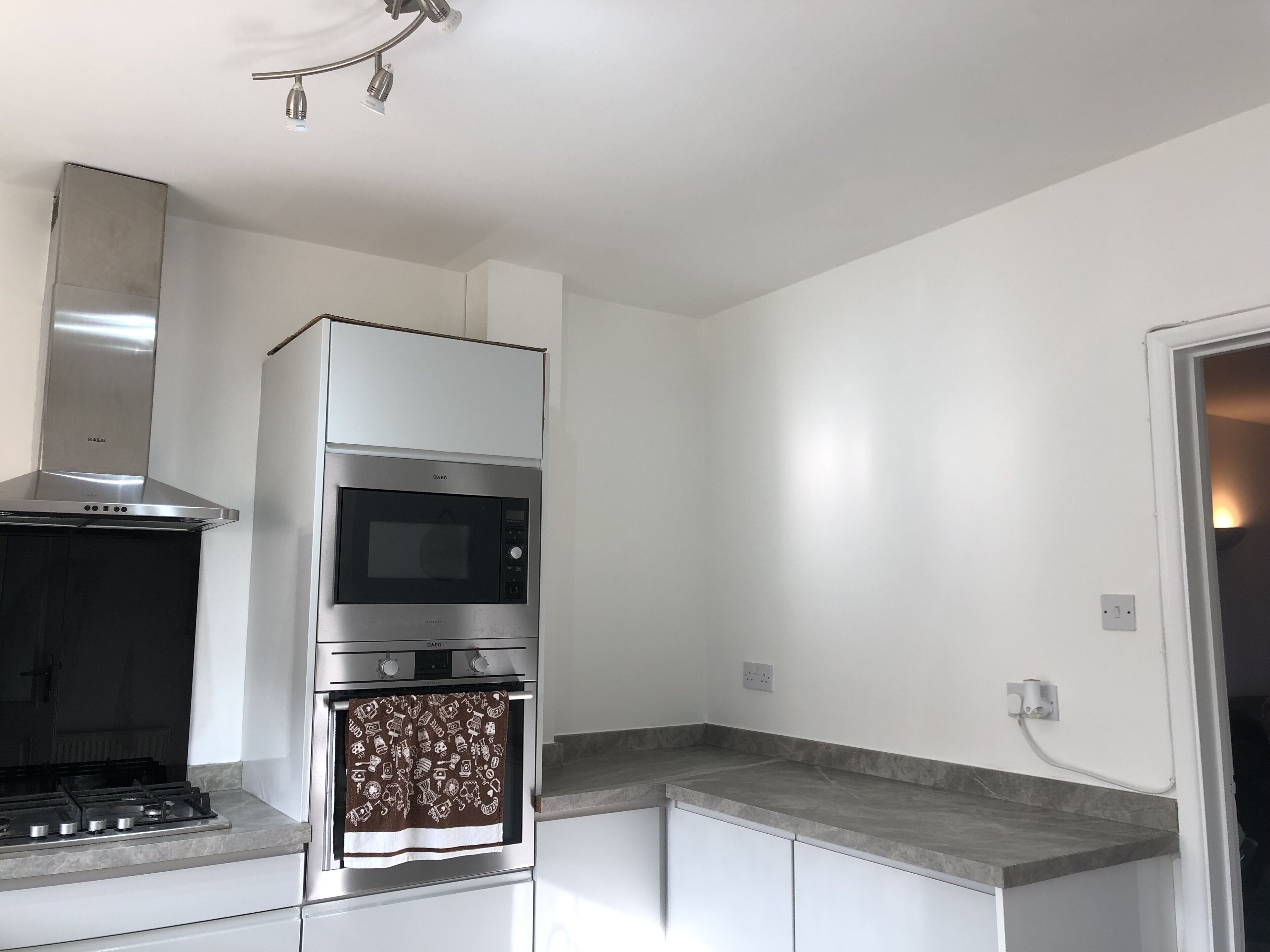 A modern kitchen with a built-in oven, microwave, and gas stove.
