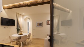 A modern kitchen with a wooden countertop and a dining area with a round table and chairs. - nota-Mi - Domus Ticinese (Milan)