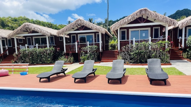 A poolside area with lounge chairs and a pool. - Red Hibiscus Villa 1 (Avarua)