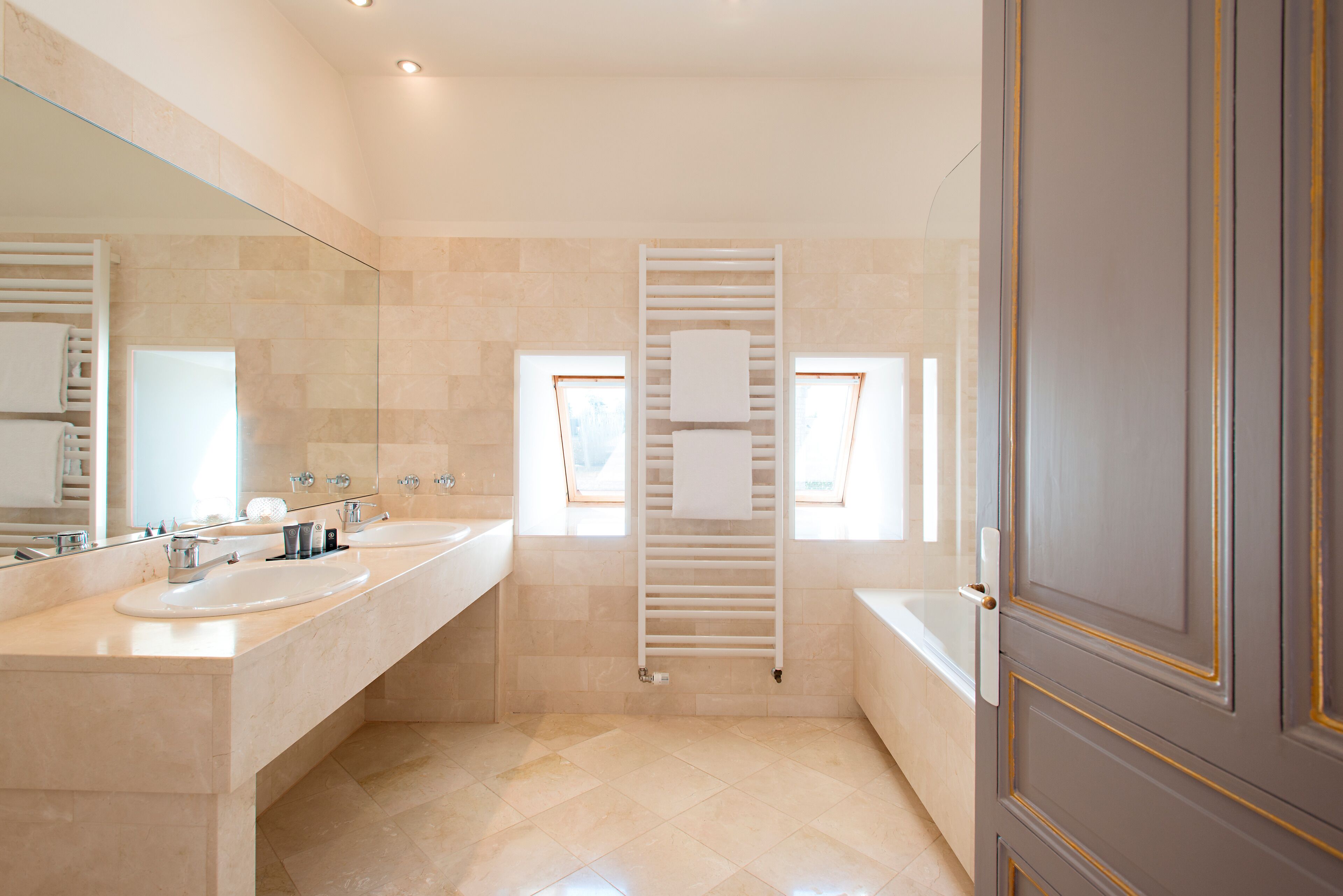 A modern bathroom with two sinks, a glass shower enclosure, and a towel rack.