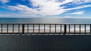 A beach view from a balcony with a railing, ocean, and a partly cloudy sky. - Seascape Elegancer Oceanfront Getaway 6th Floor (Myrtle Beach)