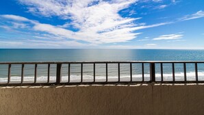 Un balcón con vista al océano y al cielo.