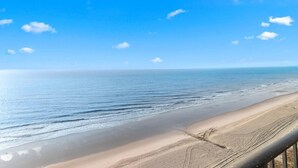 Una playa con cielo despejado y mar tranquilo.