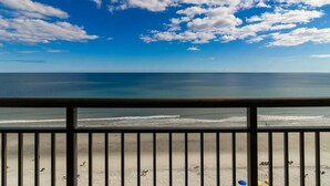 A beach view from a balcony with a railing, sandy beach, and ocean. - Seaside Serenity: 9th Floor Oceanfront Escape (Myrtle Beach)