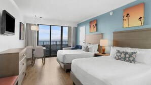 A hotel room with two beds, a desk, a chair, a TV, and a balcony with a view. - Experience Luxury Oceanfront Getaway10th Floor (Myrtle Beach)