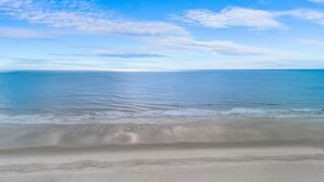 Een strand met een heldere lucht en rustige zee.