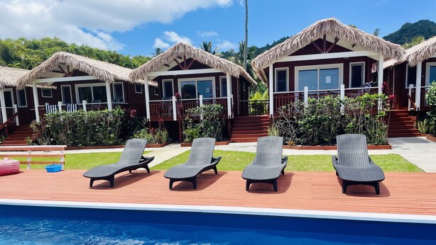 A poolside area with lounge chairs and a pool. - Red Hibiscus Luxury Home (Avarua)