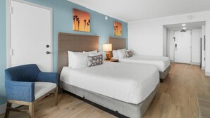 Une chambre d’hôtel avec un grand lit, une chaise et deux tableaux accrochés au mur.