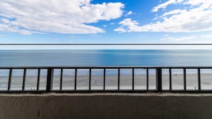 A beach view with a railing in the foreground.