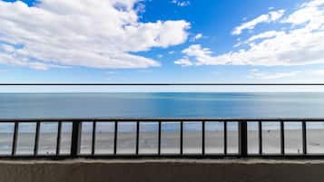 A beach view with a railing in the foreground.