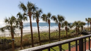 A beach view with palm trees and a clear sky. - Low Flr Oceanfront Deluxe Queen Parlor Efficiency (Myrtle Beach)