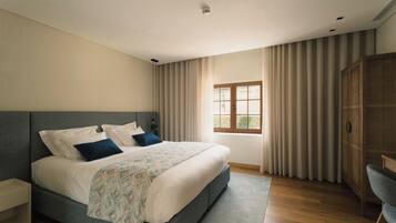 Un dormitorio con una cama grande, un armario y una ventana con cortinas.