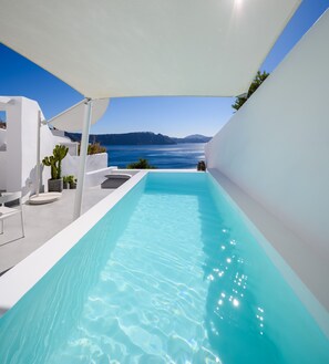 Ein moderner Infinity-Pool mit freiem Blick auf Meer und Berge.