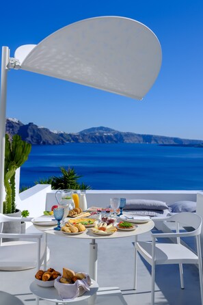 Ein Frühstückstisch mit Blick auf das Meer und die Berge.