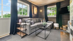 Una sala de estar moderna con un sofá gris, una mesa de centro y una chimenea.