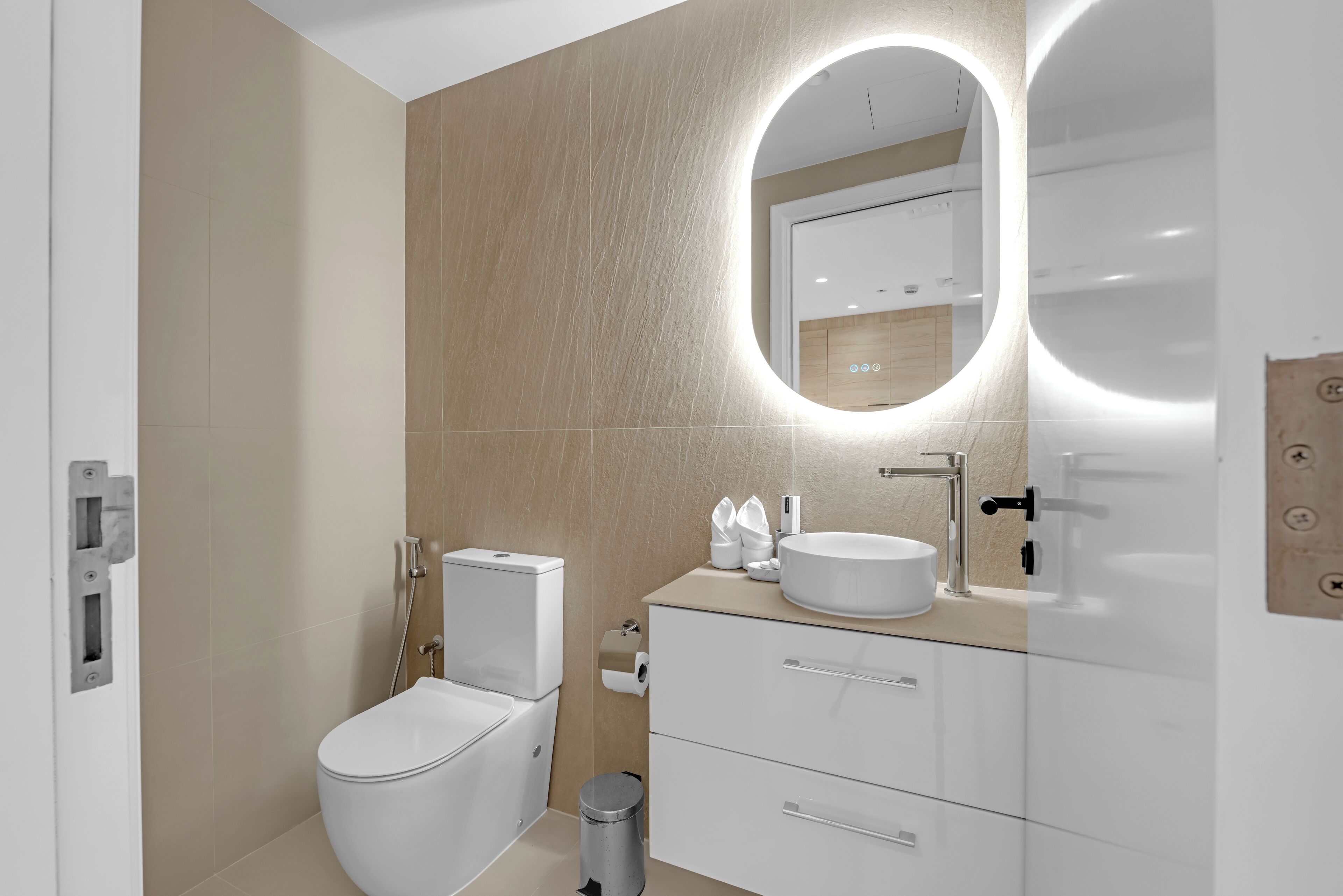 Een moderne badkamer met toilet, wastafel en badkamermeubel.