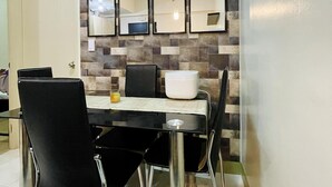 Un coin repas avec une table noire, quatre chaises et un bol blanc.