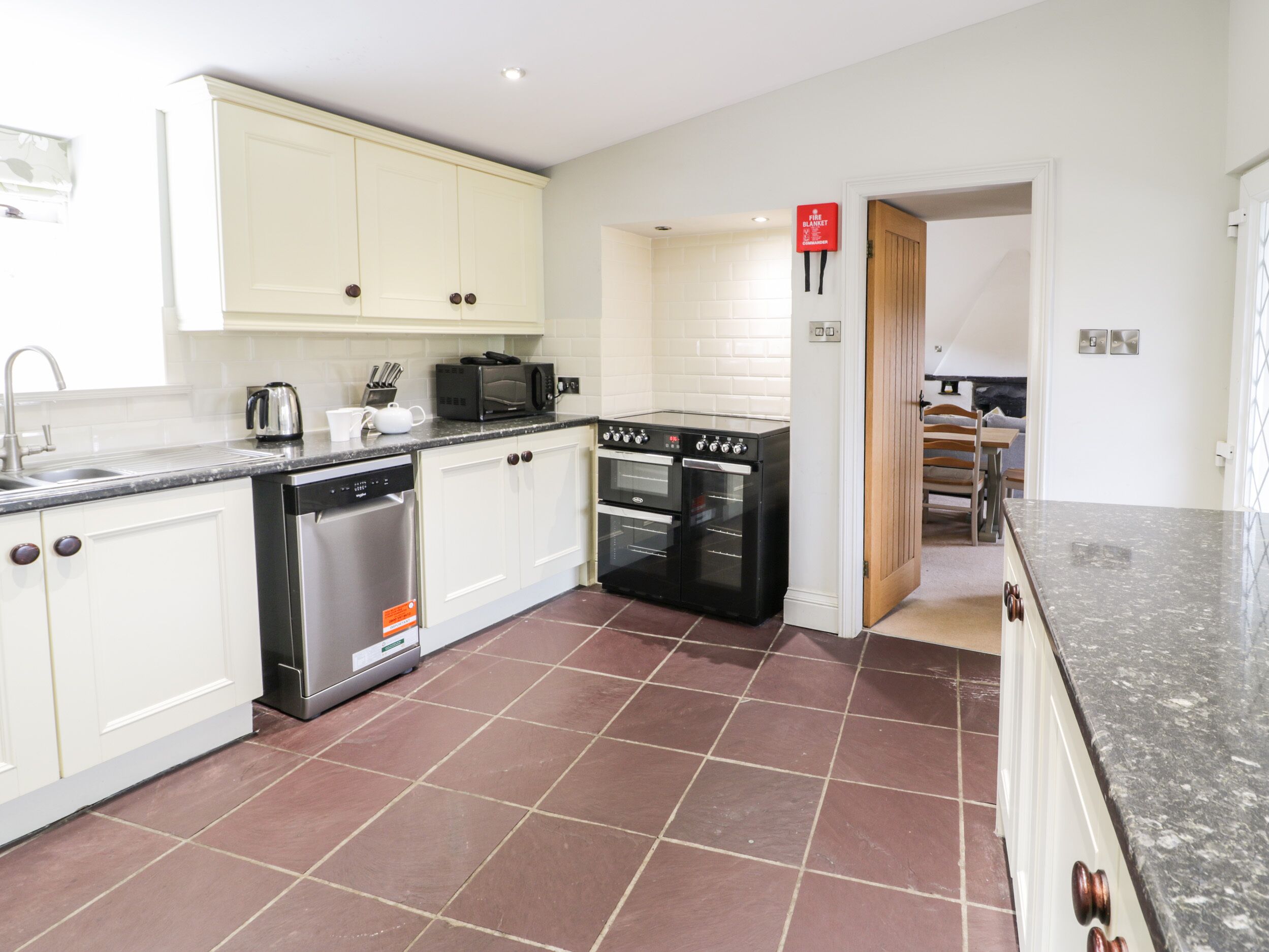 A modern kitchen with white cabinets, a black oven, and a stainless steel dishwasher.