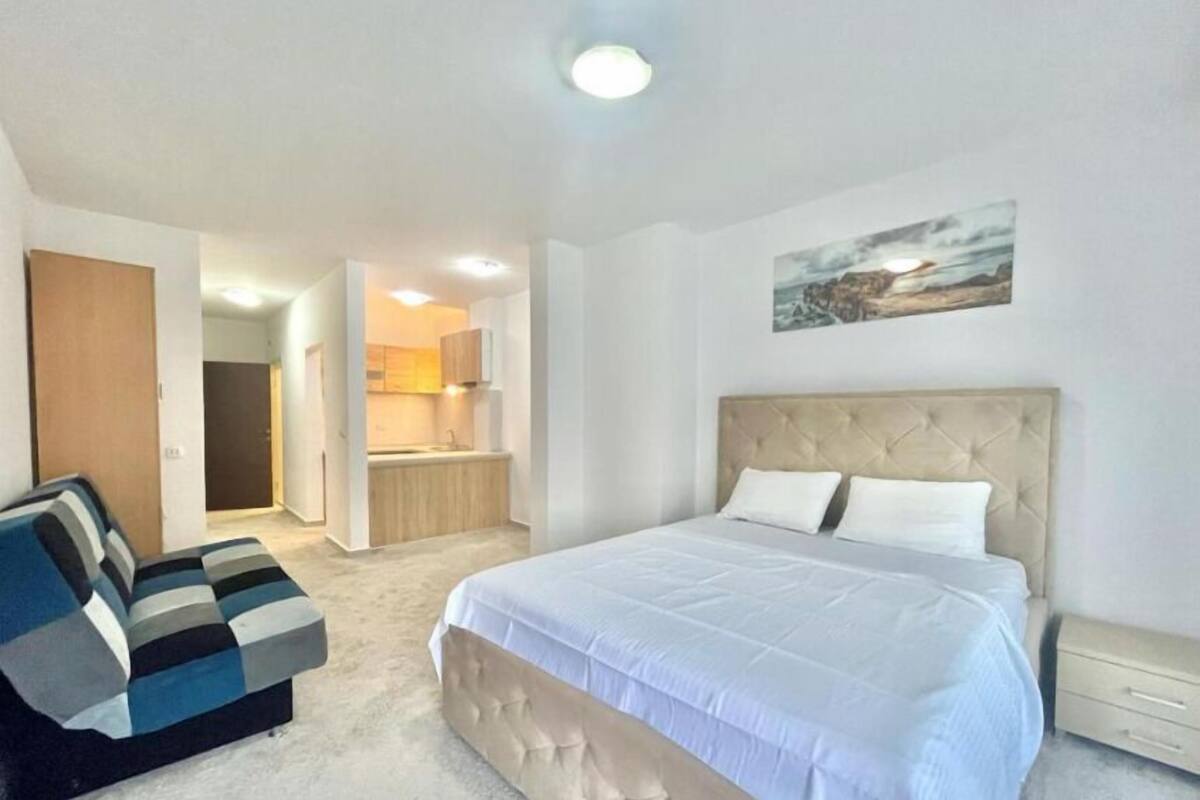 Un dormitorio con una cama grande, un sofá, una zona de cocina y un baño.