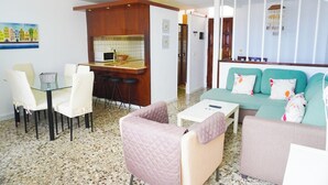 Espaço compacto com cozinha compacta, área de estar e mesa de jantar.