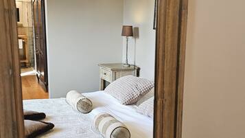 A bedroom with a bed, a nightstand, a lamp, and a mirror.