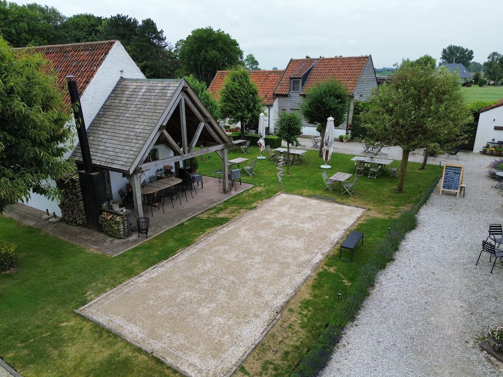 A courtyard with outdoor seating, a covered area, and a gravel path.