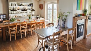 Ein geräumiger Essbereich mit Holzboden und einem großen Tisch, umgeben von Stühlen.
