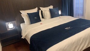 A hotel room with a bed, dark wooden headboard, white bedding, and a blue blanket. - Modern and Stylish! Luxury apartment for 7 in the center of Antwerp. (Antwerp)