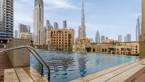 A rooftop pool with a city skyline in the background. - Waves - Chic Apartment With Dubai Skyline Views (Dubai)
