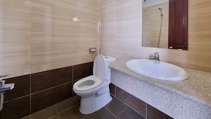 Ein modernes Badezimmer mit Toilette, Waschbecken und Spiegel.