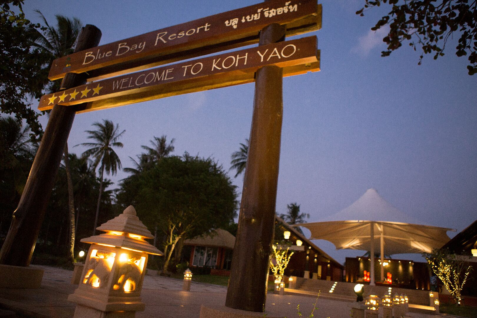 Un panneau indicateur sur lequel on peut lire « Blue Bay Resort » et « Bienvenue à Koh Yao ».