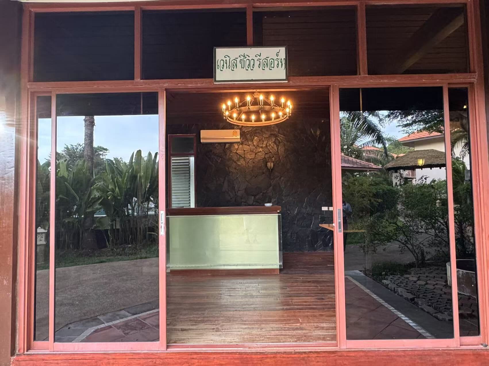 A reception area with a stone wall, a chandelier, and a sign above the entrance.