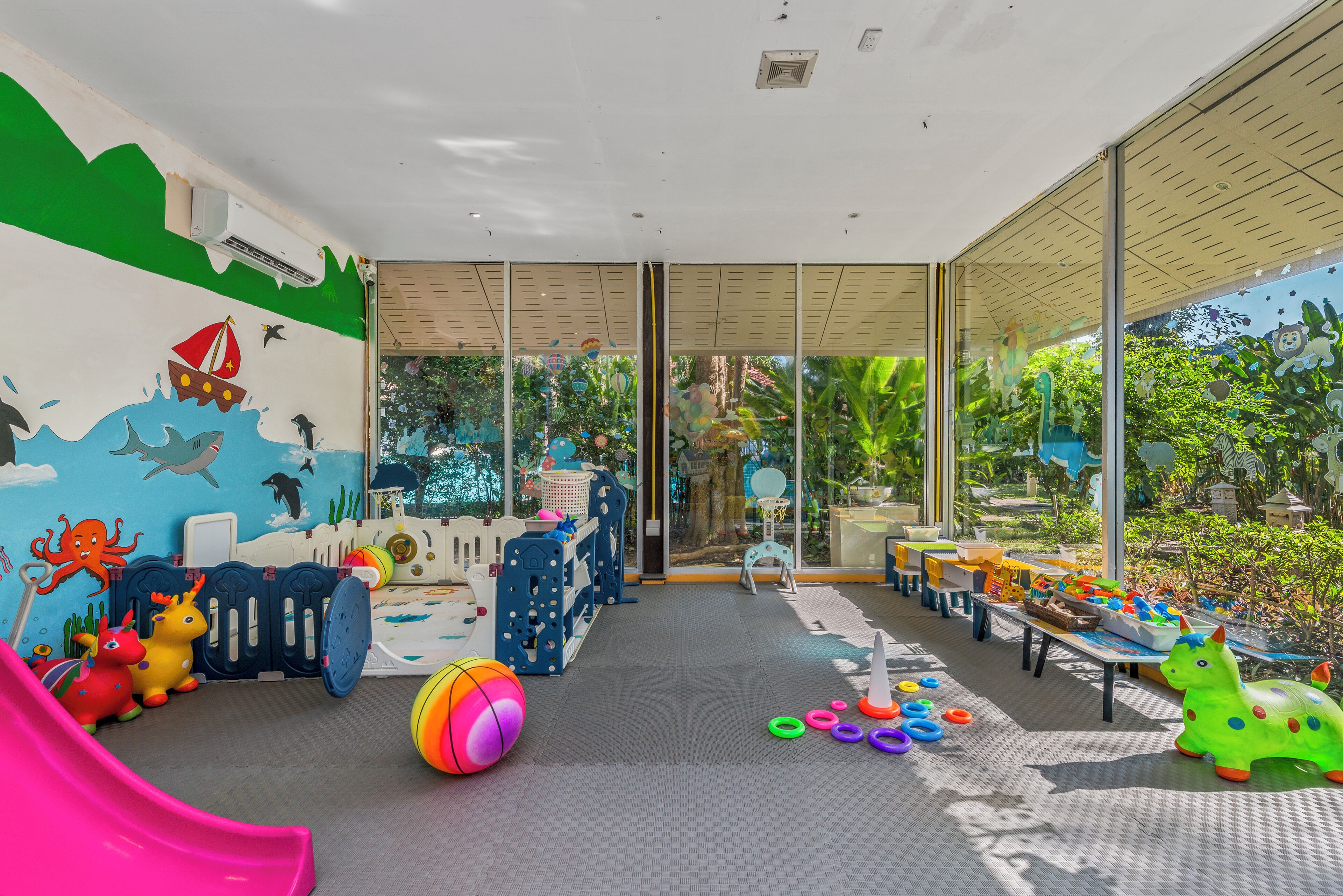 A children's play area with a slide, play mats, and various toys.