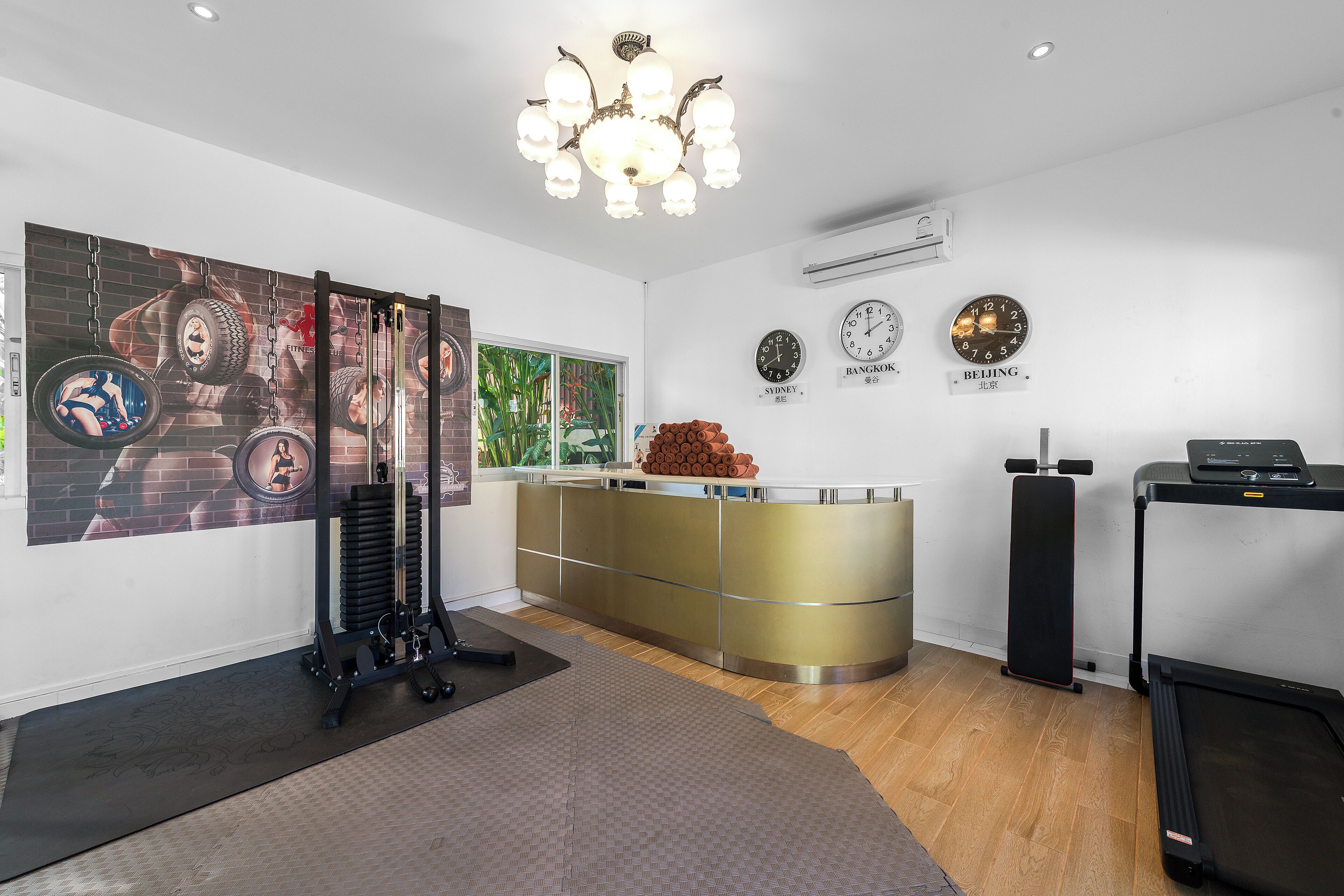A modern gym with exercise equipment, a large mirror, and clocks displaying different cities.