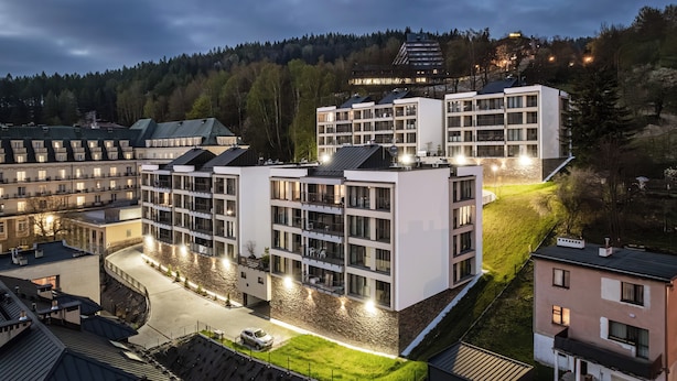 A modern hotel with multiple floors, balconies, and a courtyard. - Apartamenty Sun & Snow Cicha (Krynica-Zdroj)