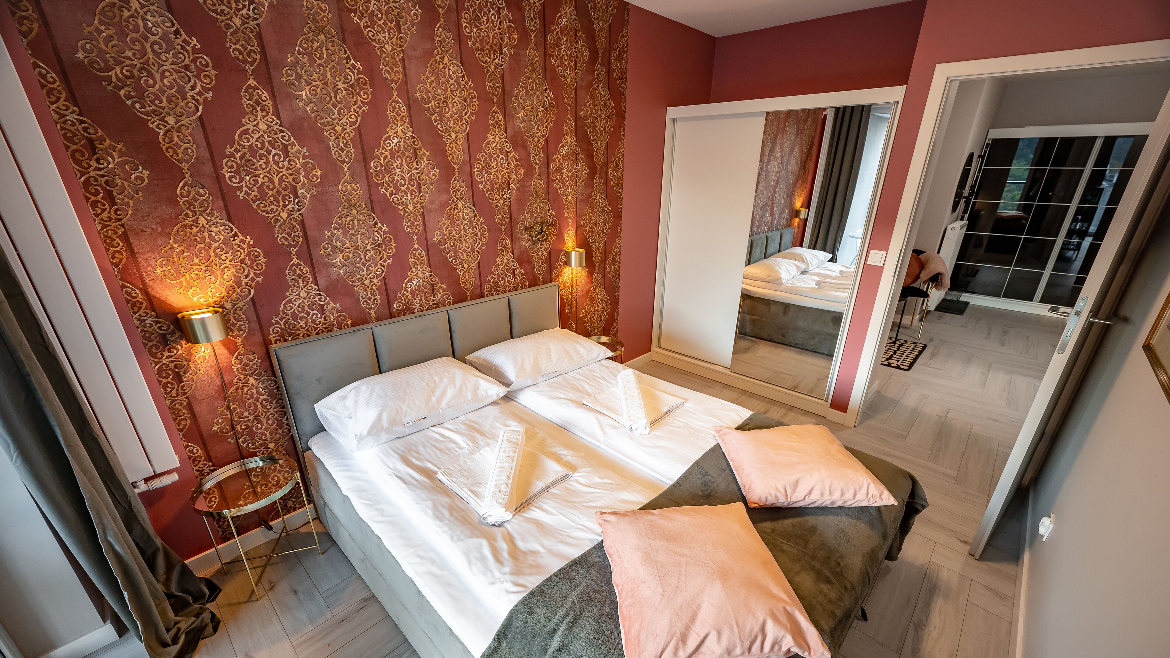 Une chambre à coucher avec un grand lit, un miroir et une table de chevet.