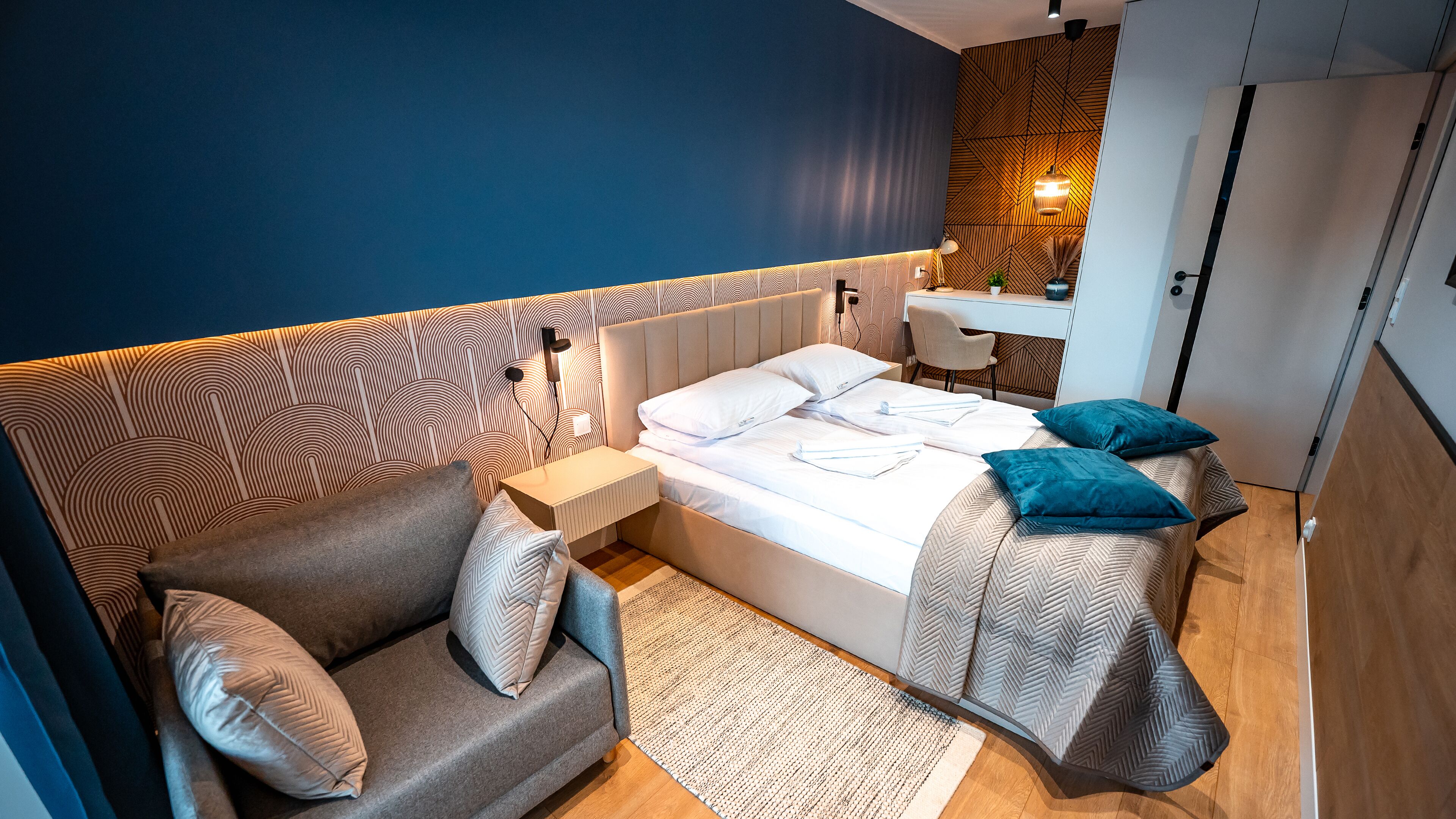 Un dormitorio moderno con cama, sofá y escritorio.