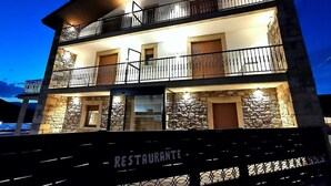 Un edificio de varios pisos con balcones y un letrero de restaurante.