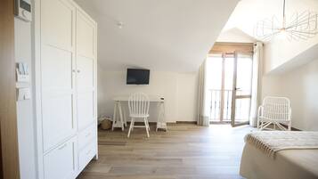 Une chambre à coucher comprenant un lit, un bureau avec une chaise, une télévision et une armoire.