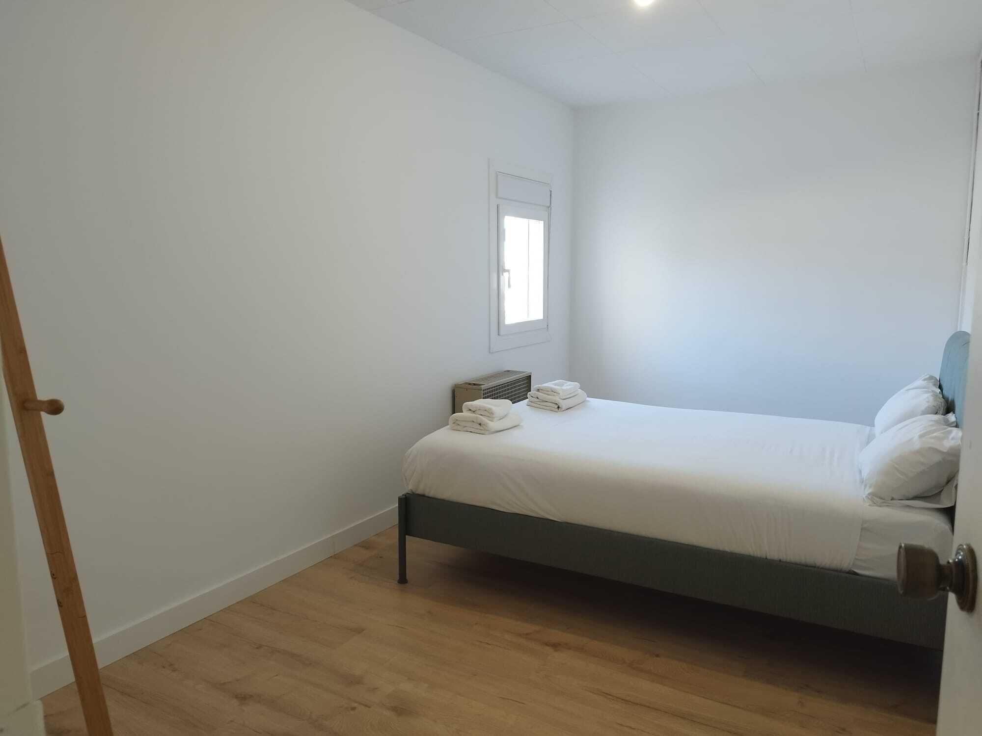 A small, clean room with a single bed, a radiator, and a window.