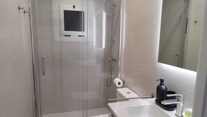 A modern bathroom with a glass-enclosed shower, a white toilet, and a sink with a mirror above it. - Feel Welcome Barcelona Splau (Cornella de Llobregat)