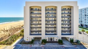 Een hotel met meerdere verdiepingen en balkons, nabij een strand.