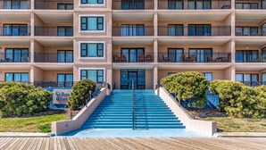 Ein mehrstöckiges Hotel mit einer zentralen Treppe, die zum Eingang führt.