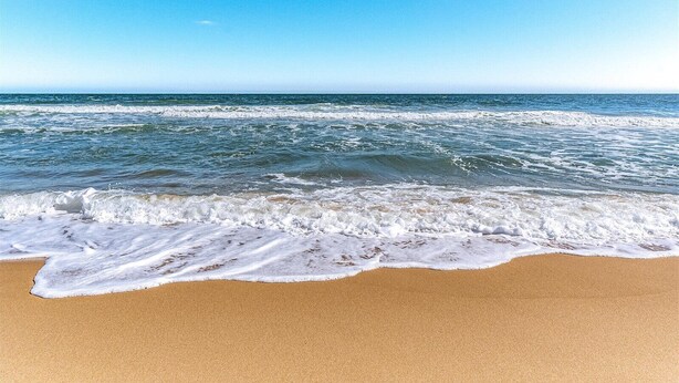Ein Strand, auf den Wellen zulaufen.
