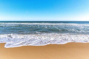 Una playa con olas acercándose a la orilla.